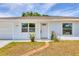 A well-maintained home with tidy landscaping, a brick path to the front door, and an attached garage at 6611 2Nd Ne Ave, Bradenton, FL 34208