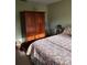 Bedroom features an armoire and a bed with a floral-patterned quilt at 6902 11Th W Ave, Bradenton, FL 34209
