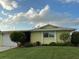 Single-story home with well-manicured lawn, blue sky and lovely landscaping at 6902 11Th W Ave, Bradenton, FL 34209