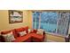 Relaxing living room corner featuring a bright red sofa and serene backyard view at 6902 11Th W Ave, Bradenton, FL 34209