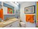 Bright bathroom with colorful accents, featuring a vanity with drawers and cabinet storage and a framed mirror at 7311 7Th W Ave # 7311, Bradenton, FL 34209