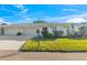 Charming single-story home with a well-manicured lawn and a two-car garage, nestled under a bright blue sky at 7311 7Th W Ave # 7311, Bradenton, FL 34209