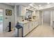 Well-lit kitchen featuring white cabinets, quartz countertops, and stainless steel appliances, next to dining area at 7311 7Th W Ave # 7311, Bradenton, FL 34209
