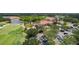 Aerial view of the clubhouse with red tile roof, lush green lawn, and golf course with pond and trees at 8005 Royal Birkdale Cir, Lakewood Ranch, FL 34202