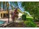 Landscaped backyard with a screened-in pool, vibrant plants, and a grassy area at 8005 Royal Birkdale Cir, Lakewood Ranch, FL 34202
