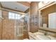 Well lit bathroom featuring glass shower, granite countertop, and a decorative mirror at 8005 Royal Birkdale Cir, Lakewood Ranch, FL 34202