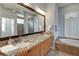 Bathroom with a large mirror over dual sinks, soaking tub, and walk-in shower at 8005 Royal Birkdale Cir, Lakewood Ranch, FL 34202