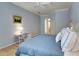Light blue bedroom featuring a comfortable bed, ceiling fan, and a white desk and chair at 8005 Royal Birkdale Cir, Lakewood Ranch, FL 34202