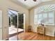 Sunlit bedroom with hardwood floors, large windows, and shutters overlooking the outdoor patio at 8005 Royal Birkdale Cir, Lakewood Ranch, FL 34202