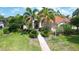 Beautiful home featuring lush landscaping, stately palm trees and a red tile roof at 8005 Royal Birkdale Cir, Lakewood Ranch, FL 34202