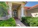 Inviting front porch with classic columns, brick walkway, manicured bushes, and an American flag at 8005 Royal Birkdale Cir, Lakewood Ranch, FL 34202