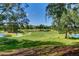 Scenic view of the lush green golf course with mature trees and a meandering path at 8005 Royal Birkdale Cir, Lakewood Ranch, FL 34202