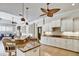 Spacious kitchen featuring a large island with seating, granite countertops, modern pendant lights and white cabinetry at 8005 Royal Birkdale Cir, Lakewood Ranch, FL 34202