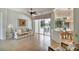 Open-concept living room with tan tile floors, sliding glass doors to the pool, and view to a water feature at 8005 Royal Birkdale Cir, Lakewood Ranch, FL 34202