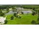 Aerial view of lake and lush grounds with winding walking paths and a center island structure at 803 Fairwaycove Ln # 102, Bradenton, FL 34212