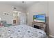 Comfortable bedroom featuring a beach themed bed, TV, cozy chair, and hallway with a bathroom at 803 Fairwaycove Ln # 102, Bradenton, FL 34212