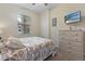 A comfortable bedroom featuring a large window, a ceiling fan, and dresser and TV at 803 Fairwaycove Ln # 102, Bradenton, FL 34212