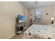 Bright bedroom featuring a cozy bed with a beach themed TV, a dresser, and a window at 803 Fairwaycove Ln # 102, Bradenton, FL 34212