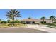 Clubhouse area with lush green tropical landscape, palm trees, and a horseshoe driveway at 803 Fairwaycove Ln # 102, Bradenton, FL 34212
