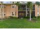Exterior view of the property with a landscaped lawn and screened patio, enhancing outdoor living at 803 Fairwaycove Ln # 102, Bradenton, FL 34212