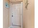 Neutral front door to property featuring secure lockbox, welcome sign, and decorative sun art at 803 Fairwaycove Ln # 102, Bradenton, FL 34212