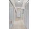 Neutral hallway with light walls, light tile flooring, and white doors with a rug at the front door at 803 Fairwaycove Ln # 102, Bradenton, FL 34212