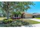 Beautiful single-story home with stone facade, palm trees, and lush green lawn at 9819 46Th E Ct, Parrish, FL 34219