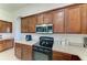 This kitchen features wooden cabinets, stainless steel microwave, and a black range oven at 9819 46Th E Ct, Parrish, FL 34219