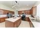Kitchen with a center island, wooden cabinetry, stainless steel refrigerator, and tile flooring at 9819 46Th E Ct, Parrish, FL 34219
