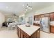 Open-concept kitchen boasts center island, pendant lighting, and stainless-steel refrigerator at 9819 46Th E Ct, Parrish, FL 34219
