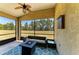 Cozy screened lanai with a ceiling fan, outdoor seating, and a peaceful view of the backyard at 9819 46Th E Ct, Parrish, FL 34219