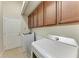 Functional laundry room with tile floors, white appliances, and overhead cabinet storage at 9819 46Th E Ct, Parrish, FL 34219