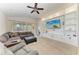Spacious living room with custom built-ins, ceiling fan, and abundant natural light at 9819 46Th E Ct, Parrish, FL 34219