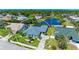 Aerial view of a house with a blue roof, pool, landscaping, and a pond in the backyard at 1008 83Rd Nw St, Bradenton, FL 34209