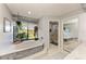 Beautiful bathroom with a soaking tub, large window overlooking the lake, and natural light at 1008 83Rd Nw St, Bradenton, FL 34209