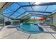 Relax in style with this screened-in pool featuring a spa and an umbrella-covered seating area overlooking the water at 1008 83Rd Nw St, Bradenton, FL 34209