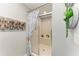 Neat shower with glass door, sitting bench, neutral tile, and decorative wall hangings at 1008 83Rd Nw St, Bradenton, FL 34209
