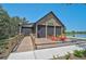 Exterior of the Outpost Activity Center featuring a screened-in porch, outdoor seating, and a serene view of the lake at 11713 Chevelon Ln, Parrish, FL 34219