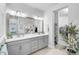 Bathroom with a double vanity, large framed mirror, walk-in closet and decorative plants at 11713 Chevelon Ln, Parrish, FL 34219