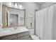 Bathroom features a vanity with quartz countertop and a framed mirror, plus a shower with a white curtain at 11713 Chevelon Ln, Parrish, FL 34219