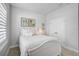 Cozy bedroom featuring white furniture, neutral walls, and soft natural light from the shuttered window at 11713 Chevelon Ln, Parrish, FL 34219
