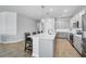 Modern kitchen with gray cabinets, pendant lights, island with seating, and stainless steel appliances at 11713 Chevelon Ln, Parrish, FL 34219