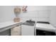 Modern laundry room with white countertops, shelving, and front-loading washer and dryer at 11713 Chevelon Ln, Parrish, FL 34219