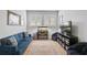 Relaxing living room featuring a comfortable blue sofa, patterned rug, and decorative aquarium at 11713 Chevelon Ln, Parrish, FL 34219