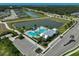 Aerial view of community pool area with palm trees, lounge chairs, and parking lot overlooking two ponds and lush greenery at 11713 Chevelon Ln, Parrish, FL 34219