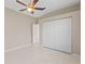 Neutral bedroom featuring tile flooring, ceiling fan, and a large closet with white doors at 12014 Beeflower Dr, Lakewood Ranch, FL 34202