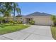 Well-maintained single-story home featuring a manicured lawn, mature palm trees and a two-car garage at 12014 Beeflower Dr, Lakewood Ranch, FL 34202