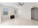 Bright living room with tile flooring, fireplace, ceiling fan, and natural light from two windows at 12014 Beeflower Dr, Lakewood Ranch, FL 34202