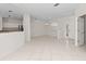 Large, tile-floored living space open to the kitchen with natural light and entry to the front door at 12014 Beeflower Dr, Lakewood Ranch, FL 34202