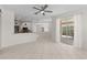 Bright open-concept living space with tiled floors, kitchen view, and sliding glass door to a patio at 12014 Beeflower Dr, Lakewood Ranch, FL 34202